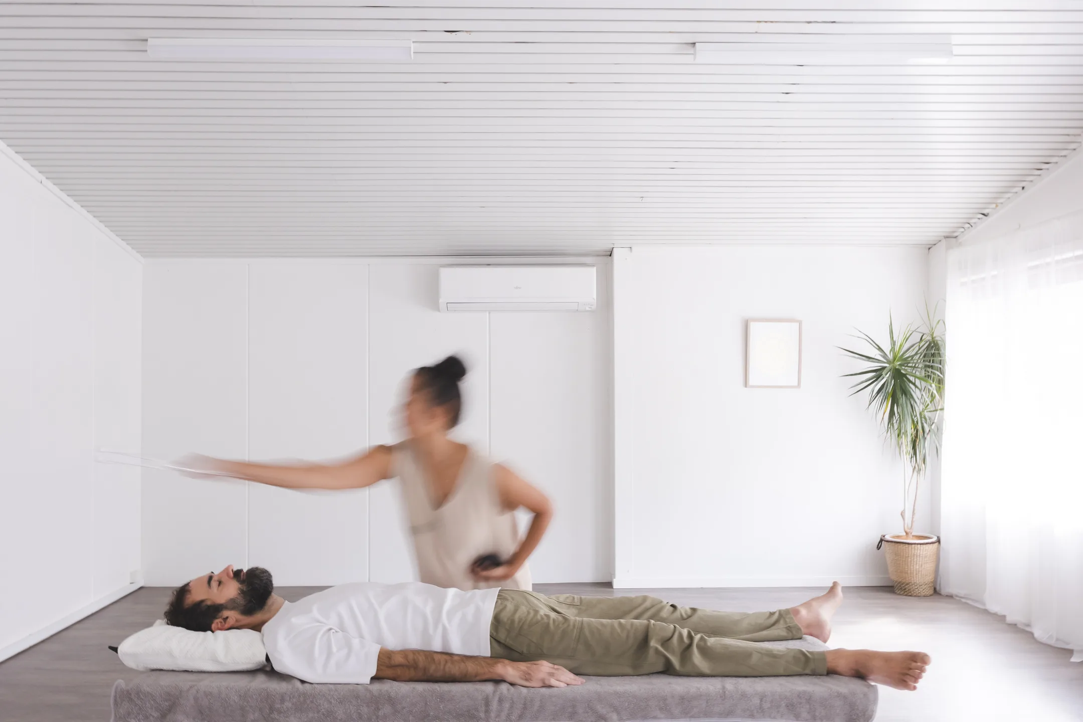 Vanessa Fernandez in motion during a biofield tuning session — long exposure captures the practitioner moving a tuning fork through the energy field around a client