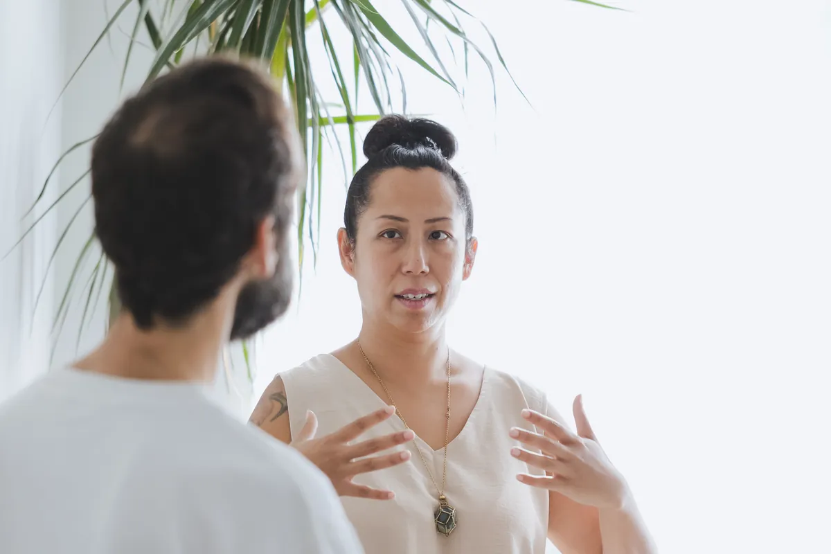 Vanessa talking with a client, both seated, her hands moving as she speaks