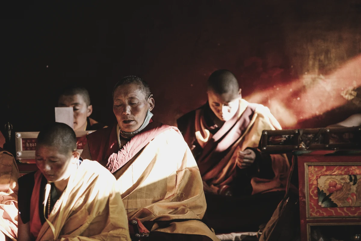 Buddhist monks chanting in warm amber light