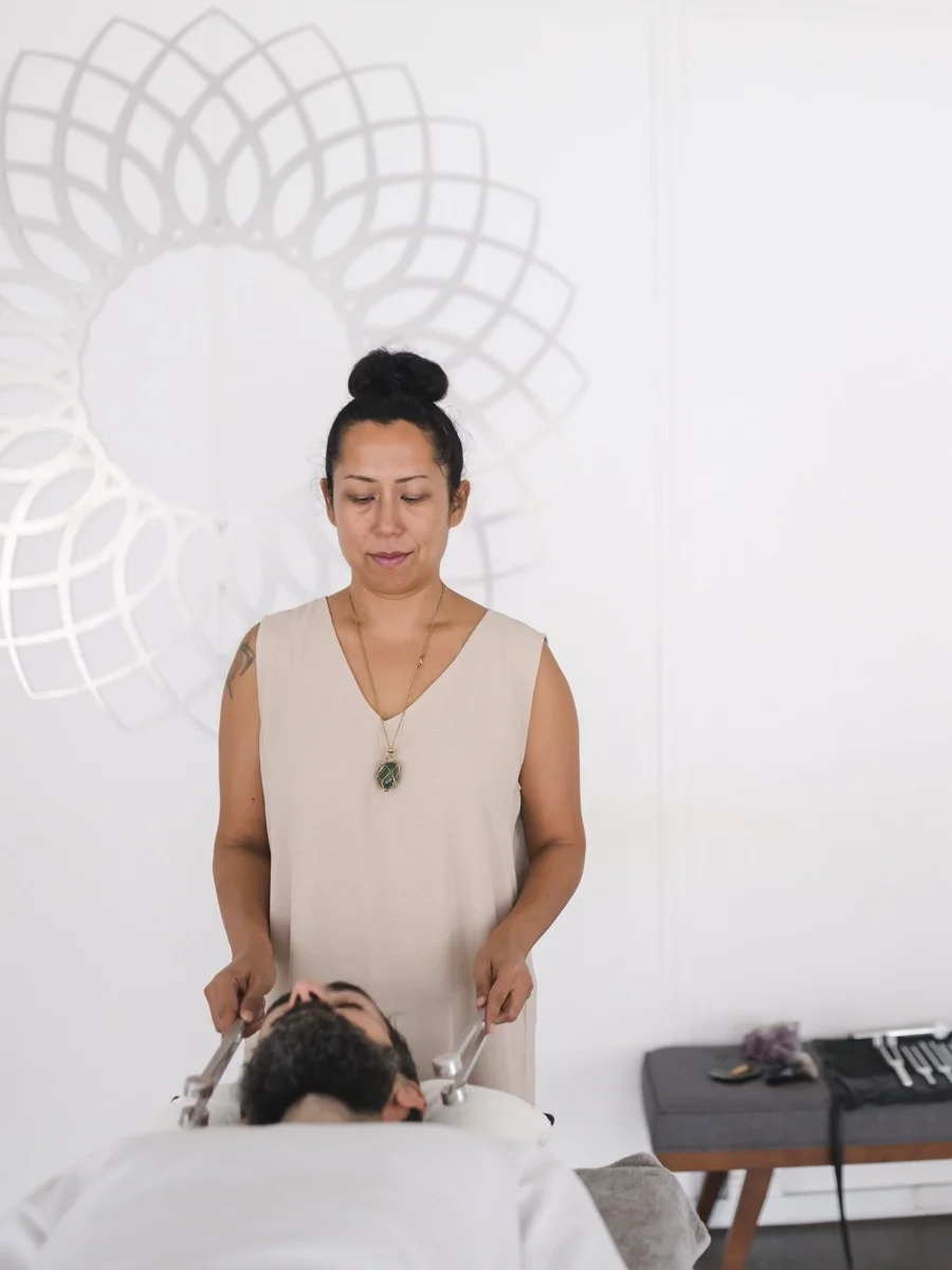 Vanessa Fernandez working with calibrated tuning forks on a client during a biofield tuning session